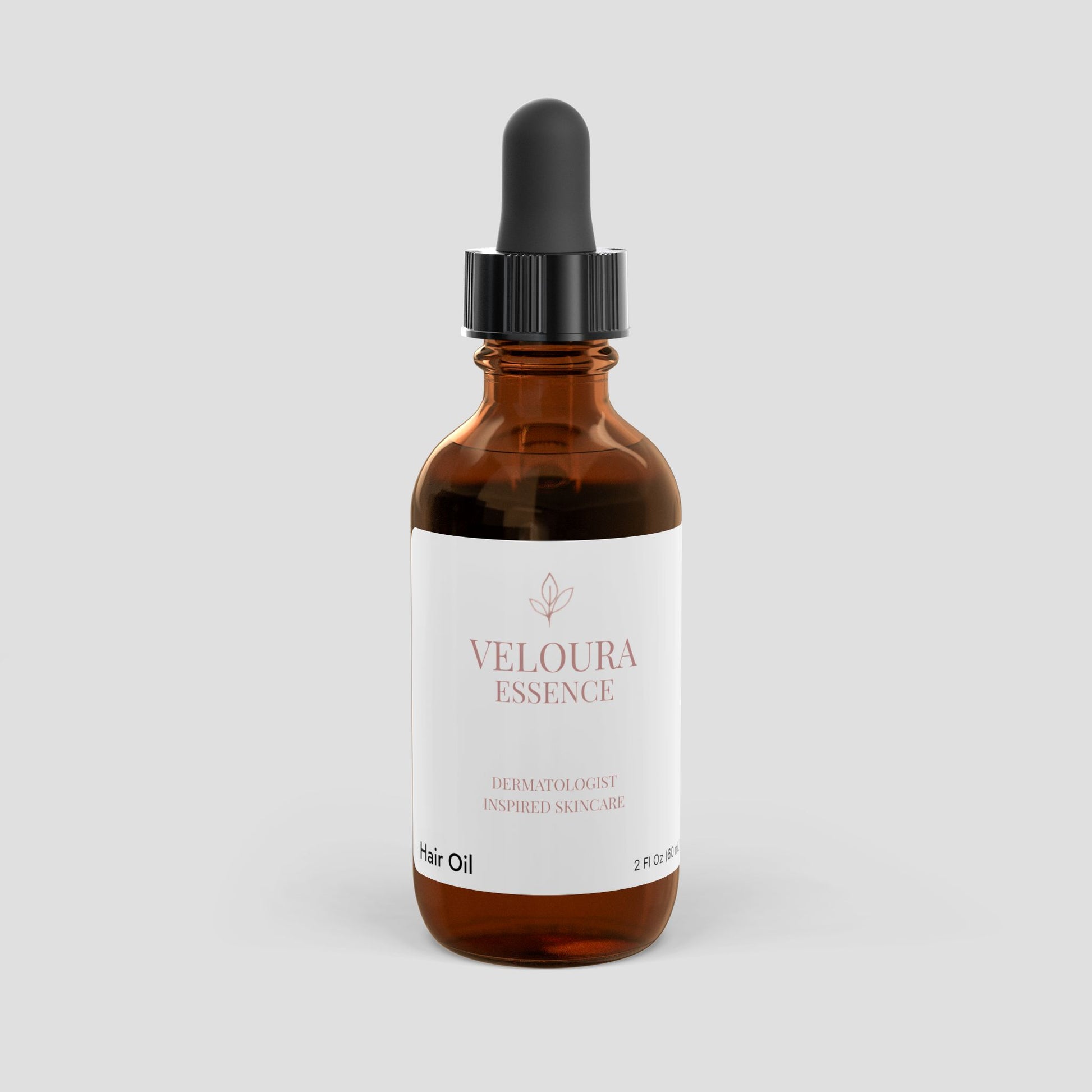 Brown bottle of Veloura Essence hair oil on a light gray background